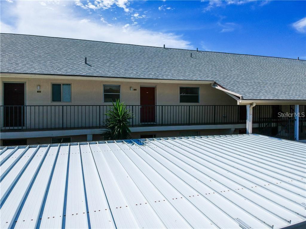 An exterior view of a multi-story apartment building with a metal roof and balcony — 525 PARKDALE UNIT 525, VENICE, FL