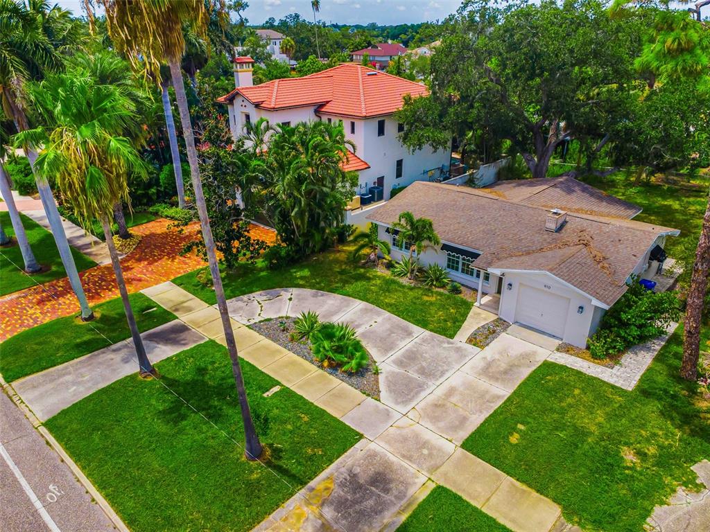 An aerial view shows a single-story house with a driveway next to a taller residence — 910 SNELL ISLE BOULEVARD NE, ST PETERSBURG, FL