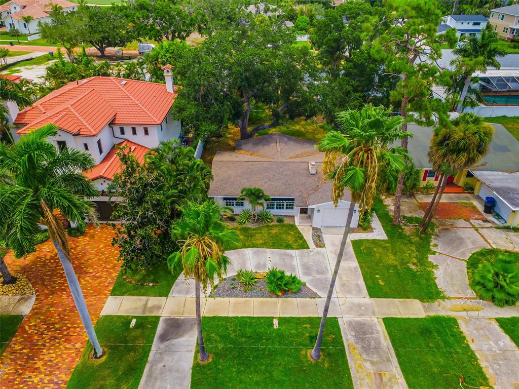 An aerial view shows a single-story house with a driveway and palm trees — 910 SNELL ISLE BOULEVARD NE, ST PETERSBURG, FL