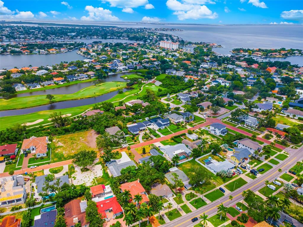 An aerial view shows a residential neighborhood with a golf course and a nearby bay — 910 SNELL ISLE BOULEVARD NE, ST PETERSBURG, FL