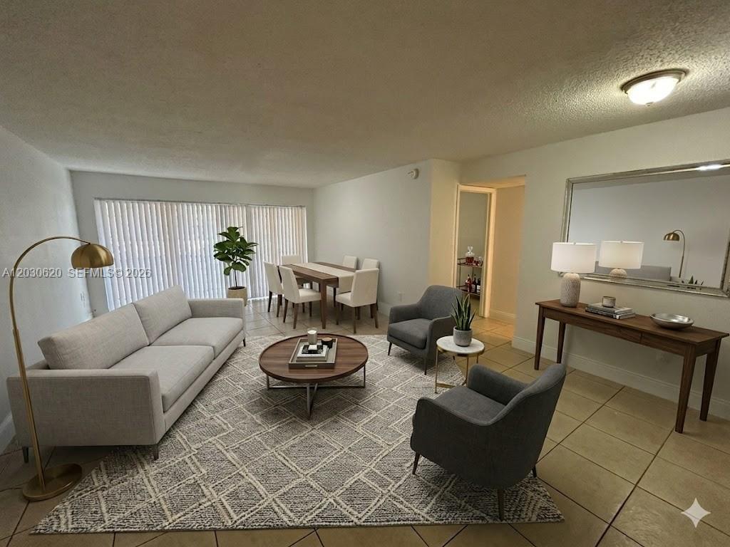 A living and dining room features a gray sofa, two armchairs, and tile flooring — 4205 N University Dr # 112, Sunrise FL 33351, SUNRISE, FL