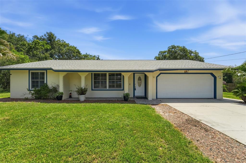 A single-story house with a light yellow exterior, a front porch, and an attached garage — 535 LAND O LAKES COURT, DELAND, FL