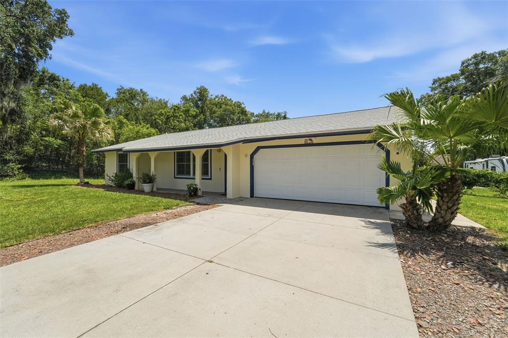 A single-story house with a beige exterior, blue trim, and a two-car garage — 535 LAND O LAKES COURT, DELAND, FL