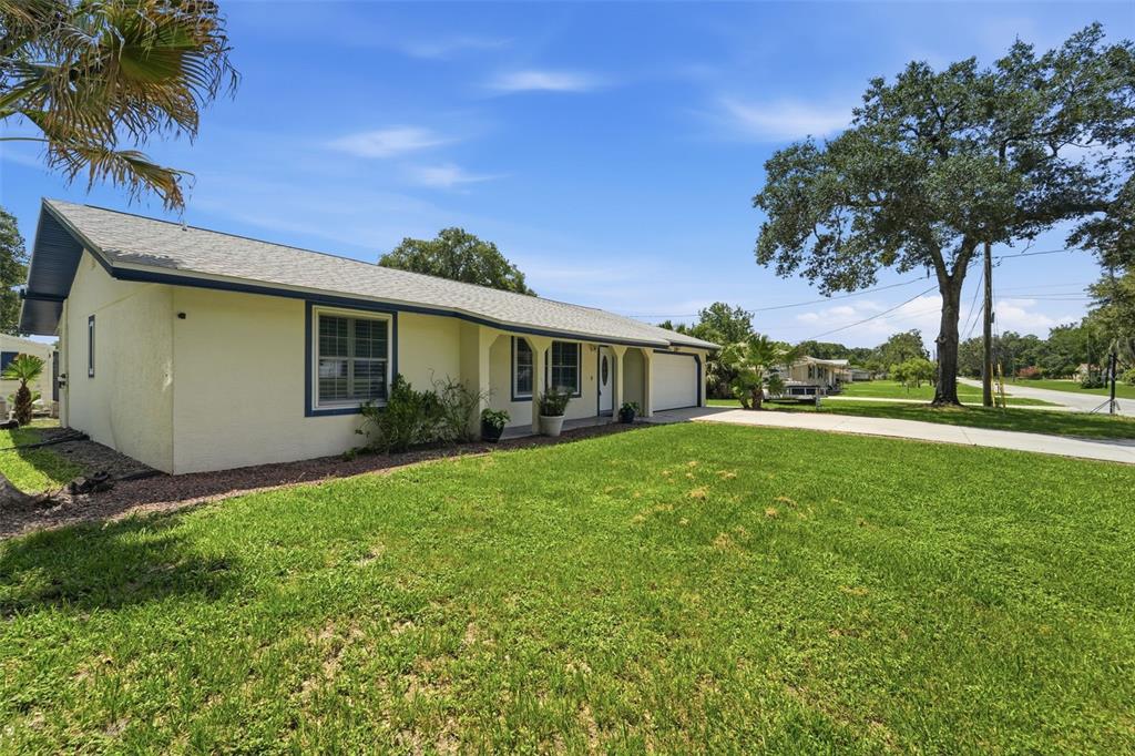 A single-story house with yellow stucco siding, a blue trim, and a concrete driveway — 535 LAND O LAKES COURT, DELAND, FL