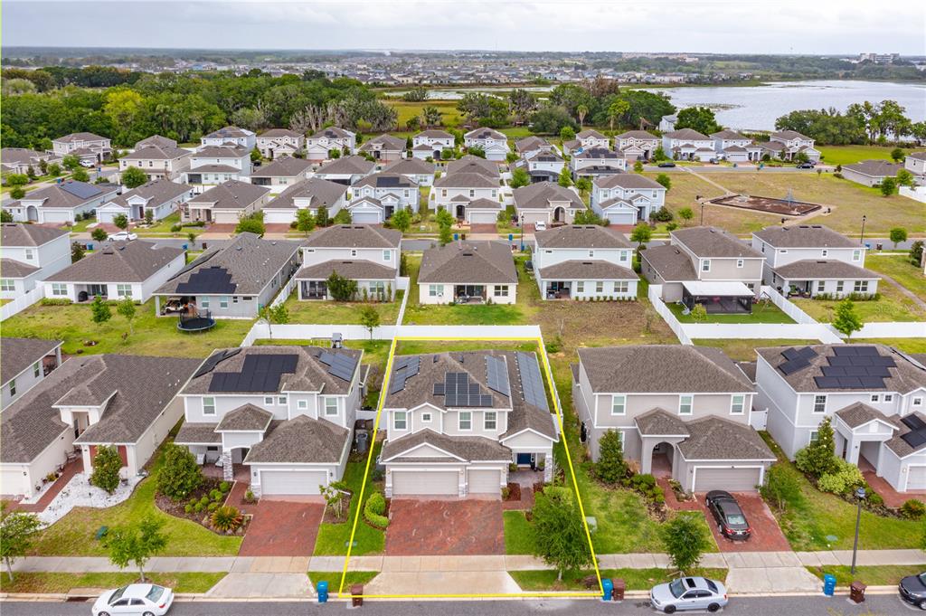 An aerial view shows a suburban neighborhood with a highlighted single-family home featuring solar panels — 1324 YORKDALE ROAD, DAVENPORT, FL