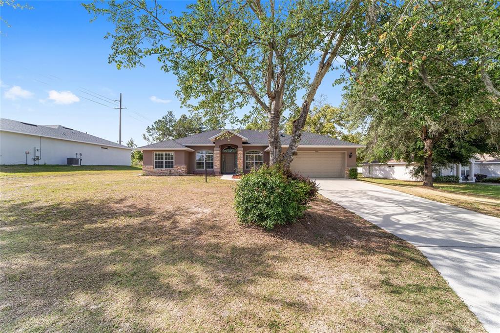 A single-story house with a stone facade, a two-car garage, and a concrete driveway — 5061 SW 109TH LOOP, OCALA, FL