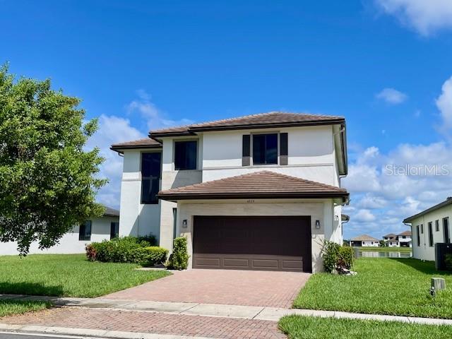 A two-story house with a brown tile roof, white stucco exterior, and a two-car garage — 4959 BRIGATA WAY, IMMOKALEE, FL