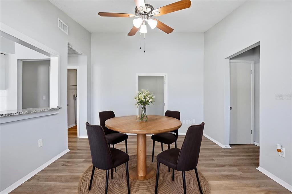 A dining area features a round wooden table, four dark chairs, and a ceiling fan — 728 E SPRUCE STREET, TARPON SPRINGS, FL