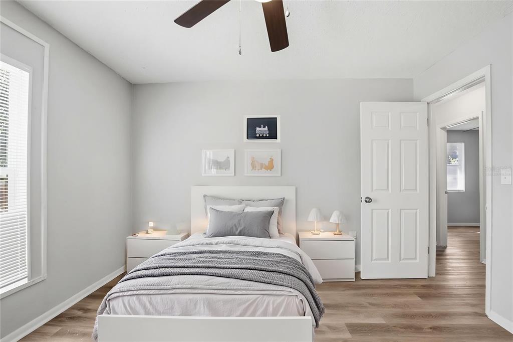 A bedroom features a white bed, two nightstands, light gray walls, and wood-look flooring — 728 E SPRUCE STREET, TARPON SPRINGS, FL