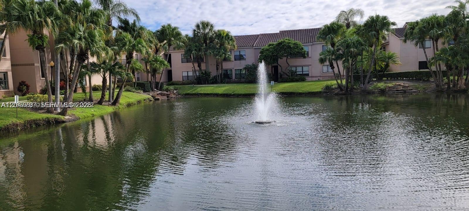 A fountain sits in a pond surrounded by palm trees and multi-story apartment buildings — 2846 S University Dr # 4308, Davie FL 33328, DAVIE, FL