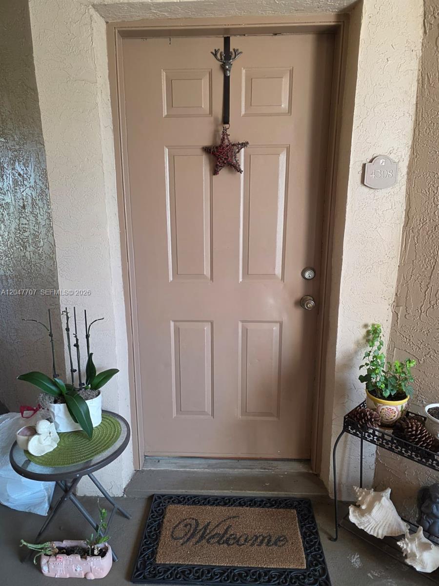 A tan front door with a star decoration and a welcome mat at the entrance — 2846 S University Dr # 4308, Davie FL 33328, DAVIE, FL