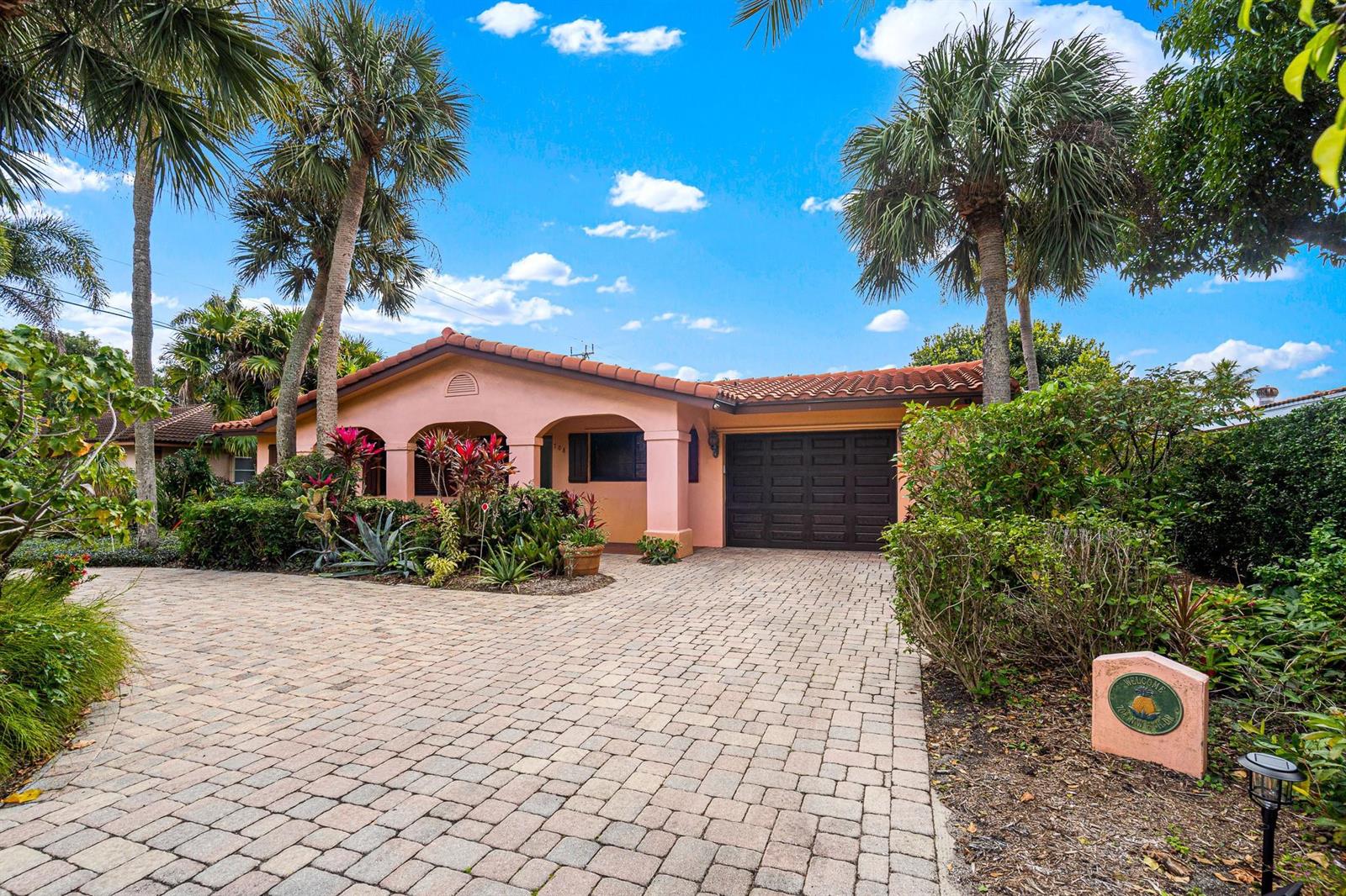 A single-story peach-colored house with a tiled roof, arched entryway, and a paved driveway — 708 NW 6th Drive, Boca Raton FL 33486, BOCA RATON, FL