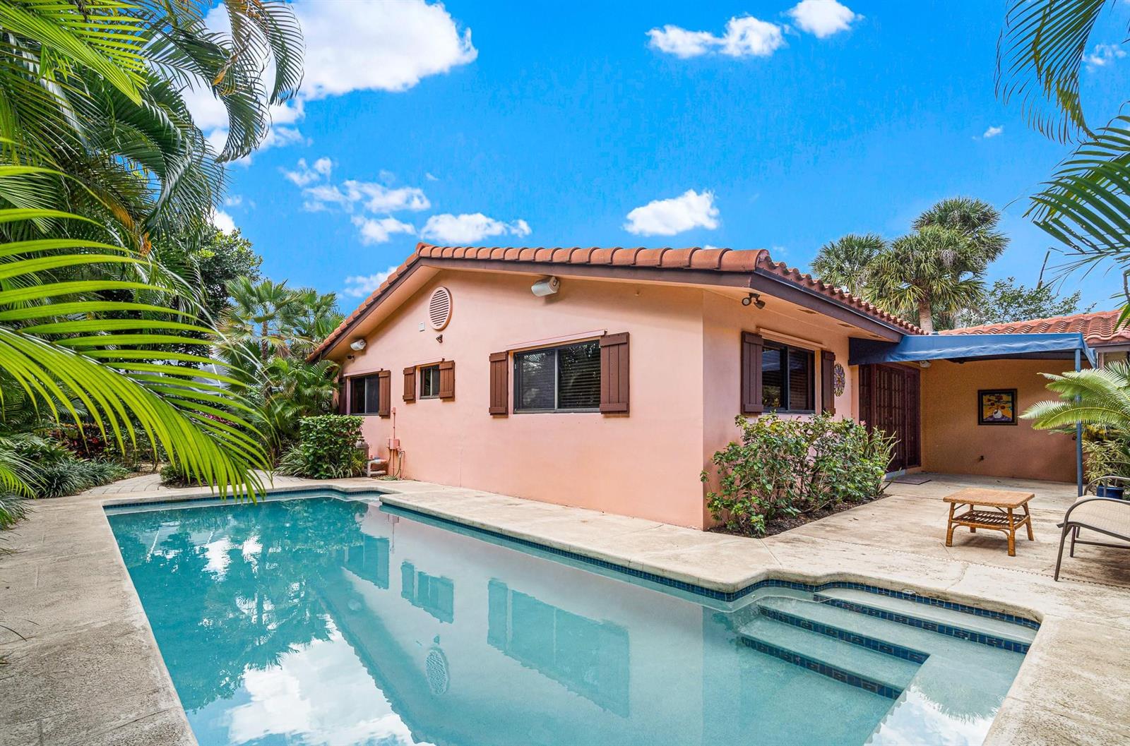 A peach-colored house with a swimming pool and a covered patio in a tropical backyard — 708 NW 6th Drive, Boca Raton FL 33486, BOCA RATON, FL