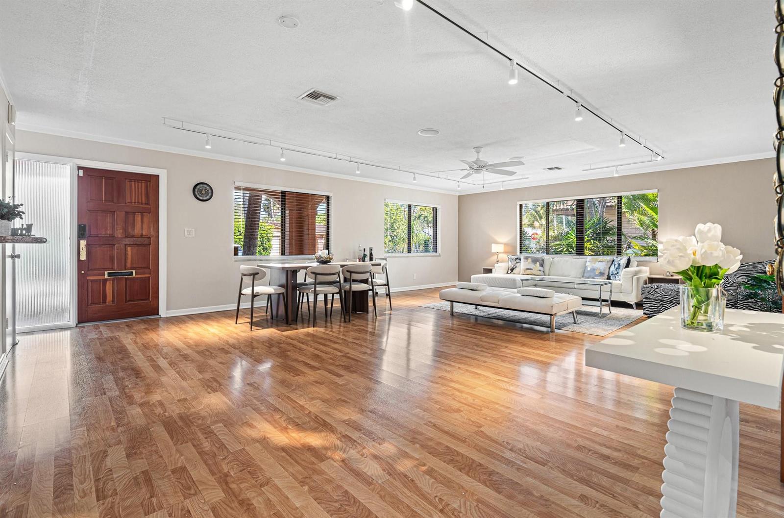 A spacious living and dining area features hardwood floors, track lighting, and a white sofa — 708 NW 6th Drive, Boca Raton FL 33486, BOCA RATON, FL