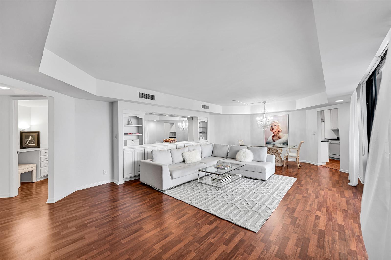 A living room features a large sectional sofa, a patterned rug, and hardwood flooring — 2860 S Ocean Boulevard # 511, Palm Beach FL 33480, PALM BEACH, FL