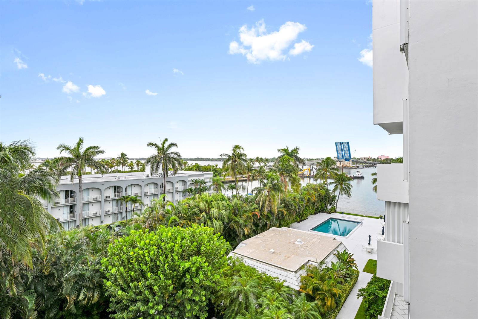 An elevated view of a swimming pool, lush tropical landscaping, and a nearby drawbridge — 2860 S Ocean Boulevard # 511, Palm Beach FL 33480, PALM BEACH, FL