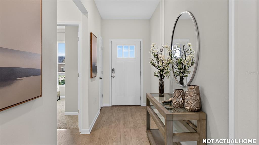 This is a rendering of an entryway featuring a console table, mirror, and white door — 155 SPRINGWOOD DRIVE, PALM COAST, FL