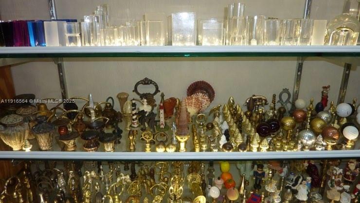 Glass shelves display a large collection of decorative figurines, brass objects, and clear glass pieces — 2178 NE 123rd St, North Miami FL 33181, NORTH MIAMI, FL