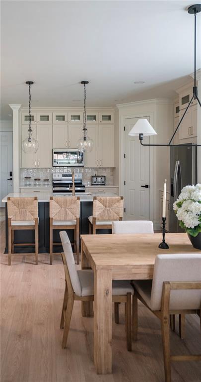 A kitchen with a center island, bar stools, and an adjacent dining area with wood furniture — 325 VILLORESI BOULEVARD, NOKOMIS, FL