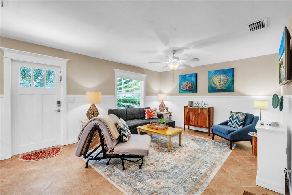 A living room features a gray sectional, a blue armchair, and a patterned area rug — 205 PEACOCK LANE UNIT A, HOLMES BEACH, FL
