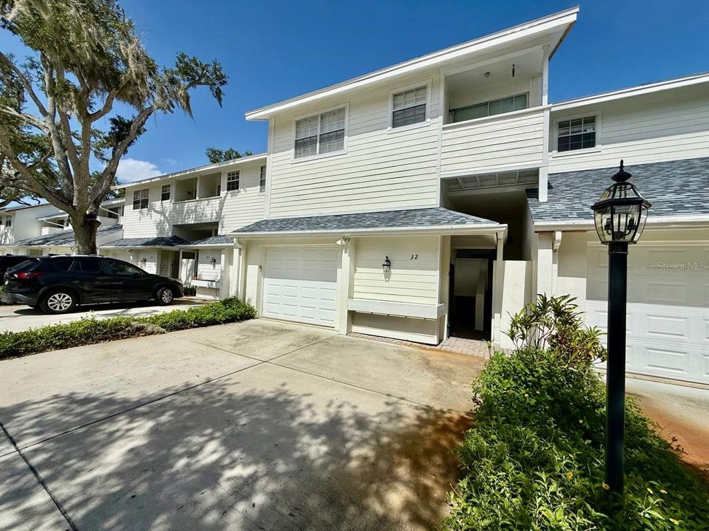 The exterior of a two-story townhouse with a white garage and a concrete driveway — 5220 S RUSSELL STREET UNIT 32, TAMPA, FL