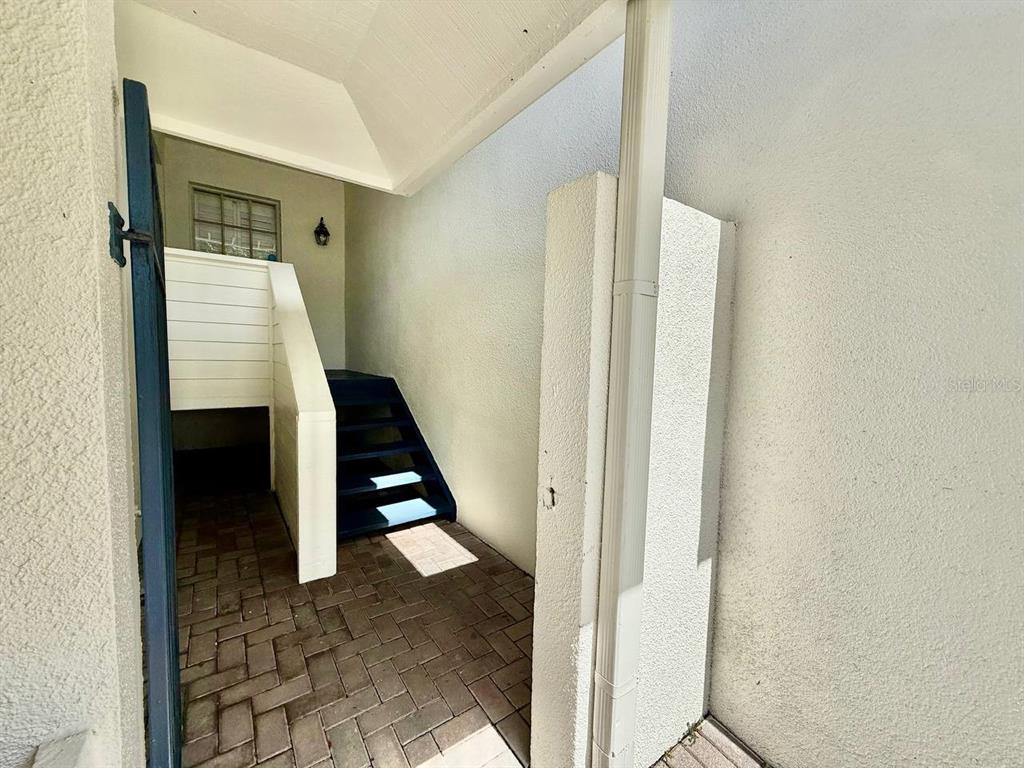 A paved entryway features a set of blue stairs leading up to a white door — 5220 S RUSSELL STREET UNIT 32, TAMPA, FL
