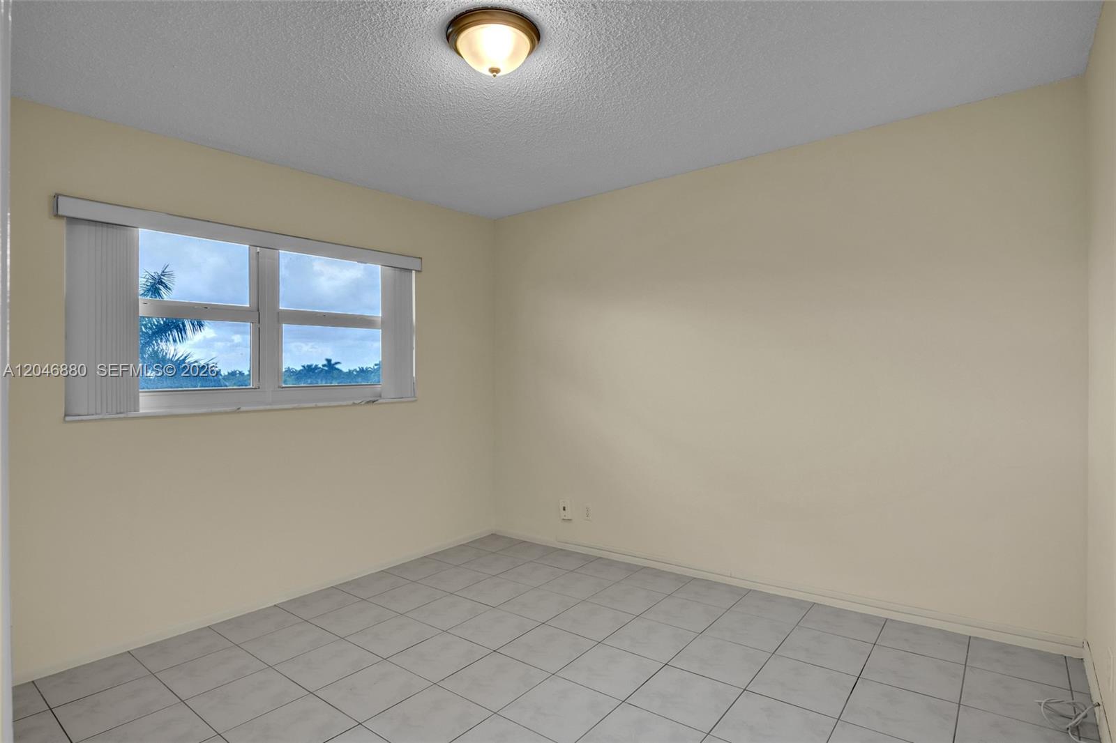 An empty bedroom features light-colored walls, white tile flooring, and a window with blinds — 1000 NE 14th Ave # 503, Hallandale Beach FL 33009, HALLANDALE BEACH, FL