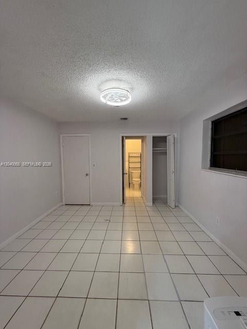 A room with white tiled floors, a ceiling light, and doorways leading to a bathroom — 5641 SW 39th St, West Park FL 33023, WEST PARK, FL