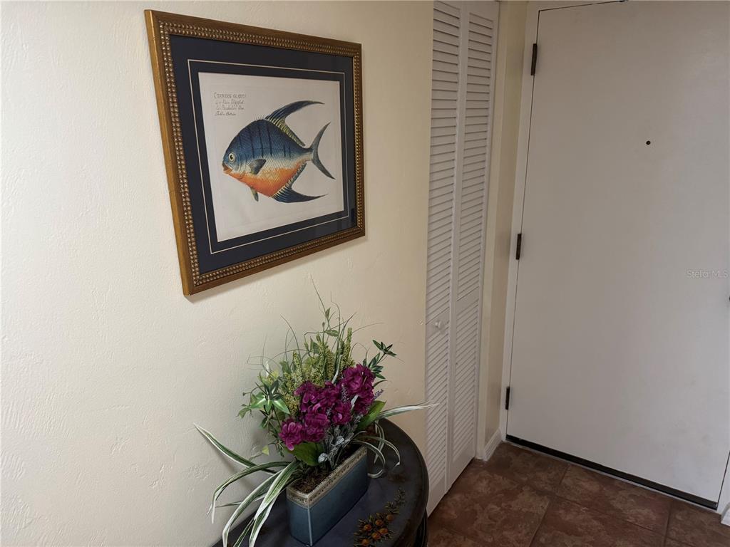 A framed fish print hangs on a wall above a small table with floral decor — 1 OCEANS WEST BOULEVARD UNIT 6B1, DAYTONA BEACH, FL