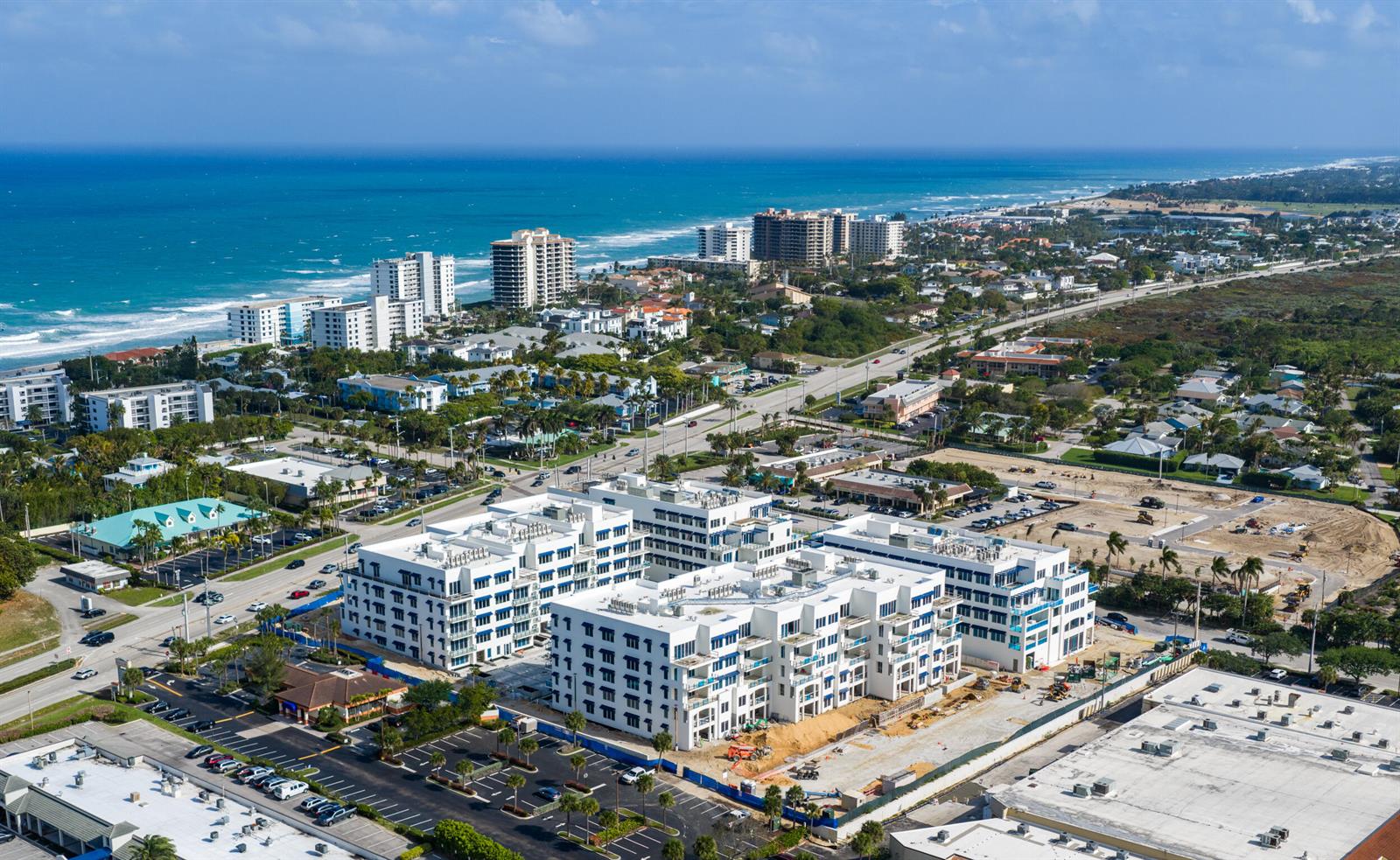 An aerial view shows a large white apartment complex under construction near the ocean — 1011 Us Highway 1 # D201, Juno Beach FL 33408, JUNO BEACH, FL