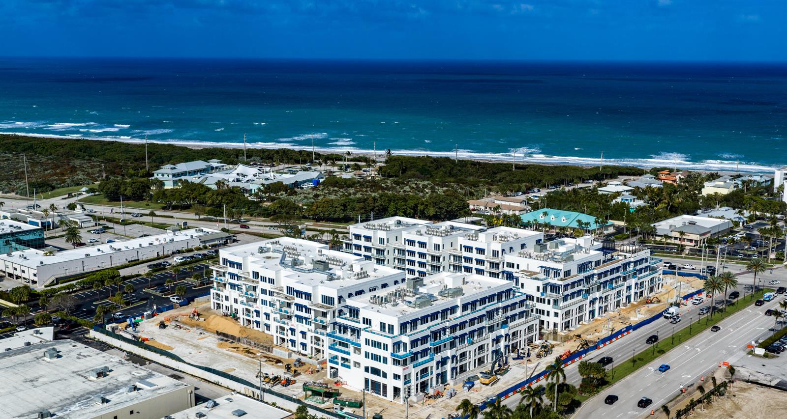 An aerial view of a large, modern white apartment complex under construction near the ocean — 1011 Us Highway 1 # D201, Juno Beach FL 33408, JUNO BEACH, FL