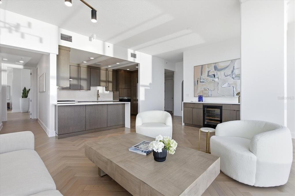 A modern open-concept living room and kitchen featuring light wood floors and white furniture — 150 E ROBINSON STREET UNIT 30C-2, ORLANDO, FL