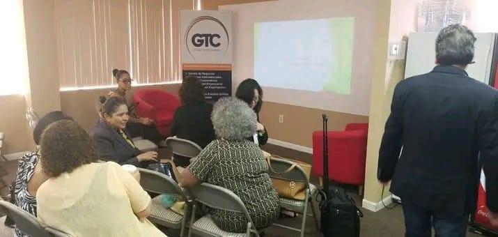 A group of people sit in chairs facing a projection screen in a meeting room — 10001 Oakland Park Boulevard # 302, Sunrise FL 33351, SUNRISE, FL