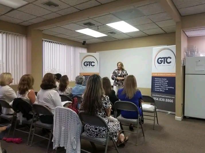 A woman presents to a seated audience in a professional office meeting room — 10001 Oakland Park Boulevard # 302, Sunrise FL 33351, SUNRISE, FL