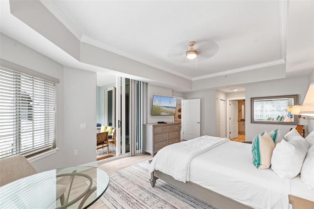 A bedroom features a bed, a dresser with a television, and a sliding glass door — 102 YACHT HARBOR DRIVE UNIT 176, PALM COAST, FL