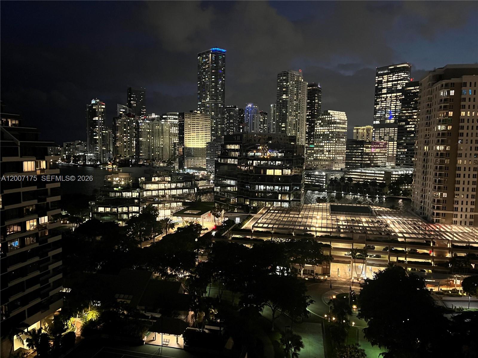 An elevated night view of a city skyline featuring numerous illuminated high-rise buildings and trees — 540 Brickell Key Dr # 1809, Miami FL 33131, MIAMI, FL
