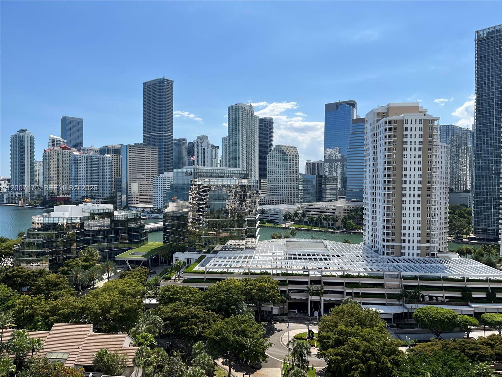 A modern high-rise apartment building features a prominent black sculpture in a circular garden bed — 540 Brickell Key Dr # 1809, Miami FL 33131, MIAMI, FL