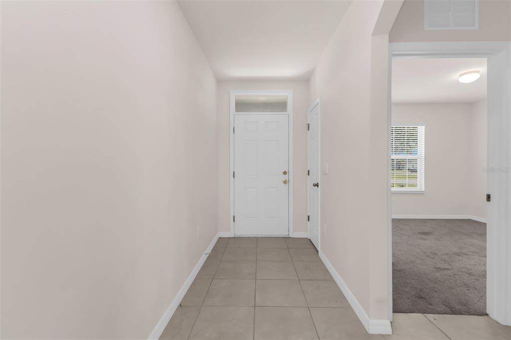 A tiled entryway leads to a white front door with a transom window — 26567 DEEP CREEK BOULEVARD, PUNTA GORDA, FL