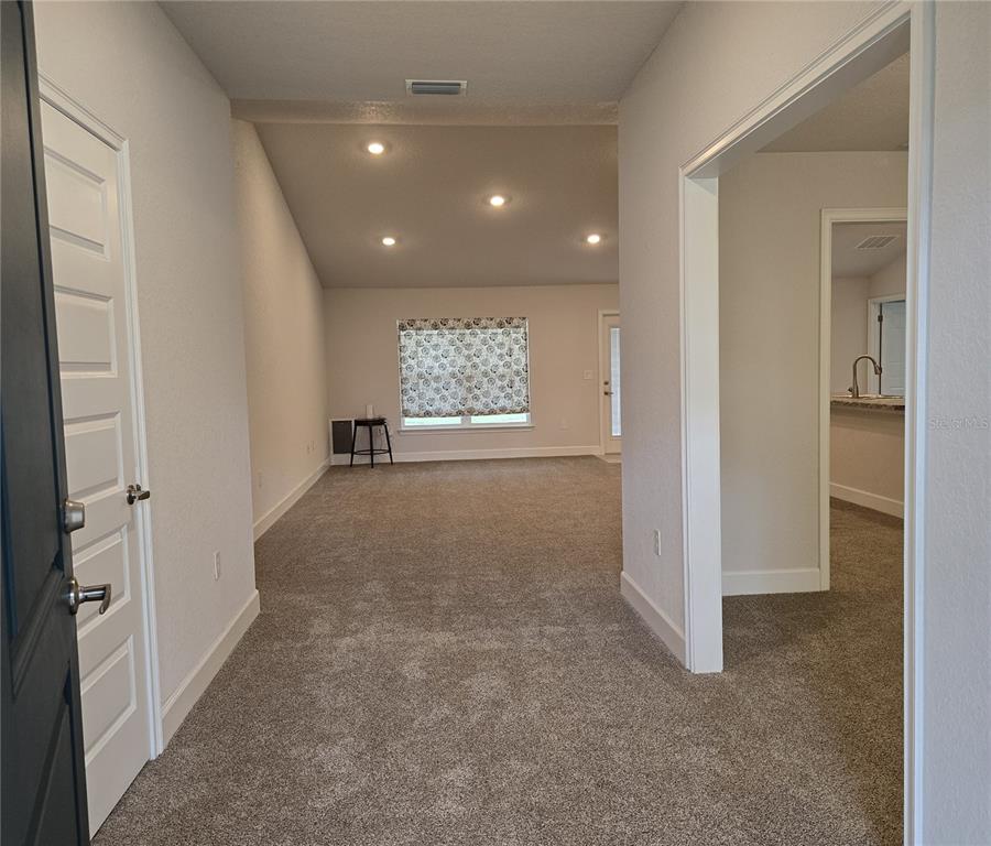 An entryway leads into a carpeted living area with vaulted ceilings and recessed lighting — 825 W HALLAM DRIVE, CITRUS SPRINGS, FL