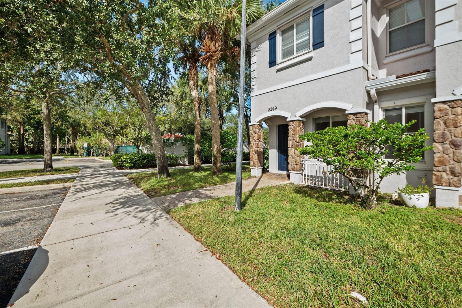 A two-story townhouse exterior features stone accents, blue shutters, and a concrete walkway — 8299 SW 27th Street # 101, Miramar FL 33025, MIRAMAR, FL