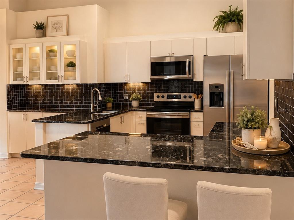 A kitchen features white cabinets, black marble countertops, and a dark tiled backsplash — 6468 NW FRIENDLY CIRCLE, PORT ST LUCIE, FL