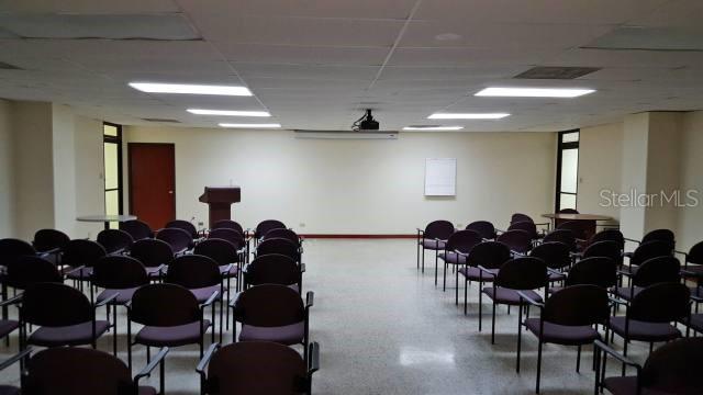A meeting room features rows of chairs facing a podium and a white projection screen — 602 BARBOSA AVE, SAN JUAN, PR