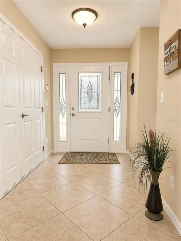 An entryway features tile flooring, a white front door with sidelights, and a ceiling light — 22348 NE 112TH TERRACE, FORT MC COY, FL
