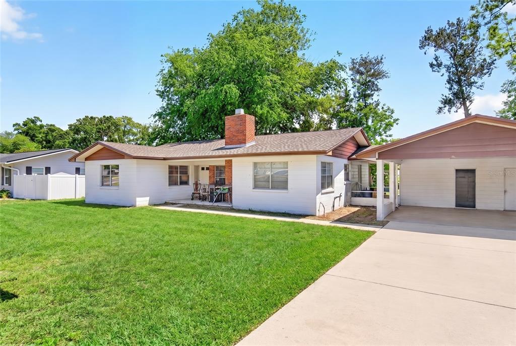 A white brick house with a red brick chimney and an attached carport — 6174 SE 125TH PLACE, BELLEVIEW, FL