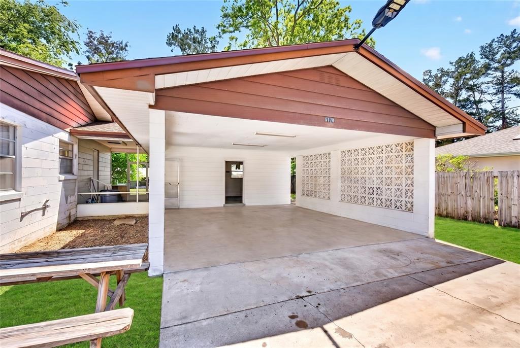 A concrete carport with a decorative breeze block wall and a wooden picnic table nearby — 6174 SE 125TH PLACE, BELLEVIEW, FL