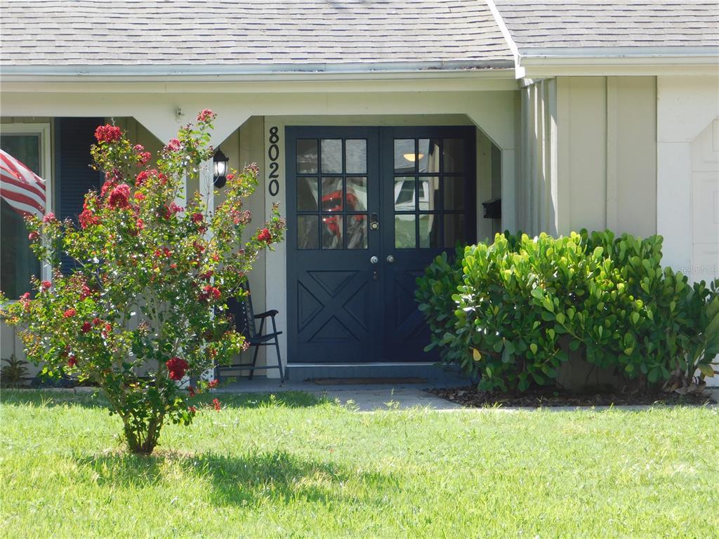 A front exterior view of a house with a dark blue double door entrance — 8020 HUNTERS WHIP ROW, HUDSON, FL