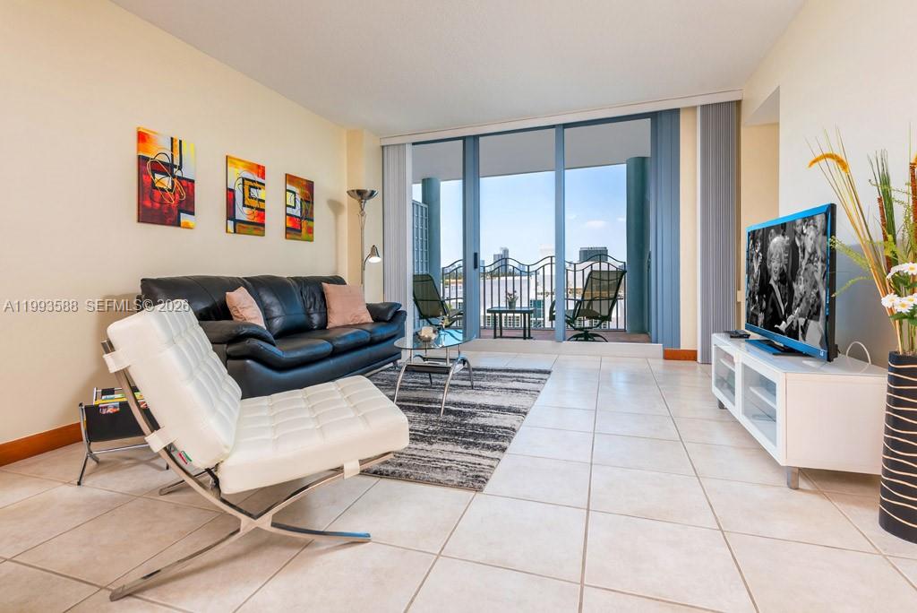 A living room features a black leather sofa, white accent chair, and balcony access — 1500 Ocean Drive # 609, Miami Beach FL 33139, MIAMI BEACH, FL