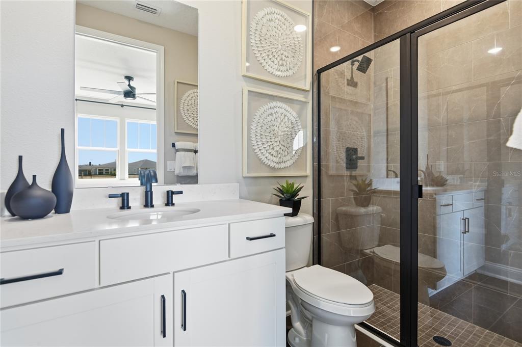 A modern bathroom features a white vanity, a glass-enclosed shower, and a toilet — 218 THORNBERRY WAY, PALM COAST, FL