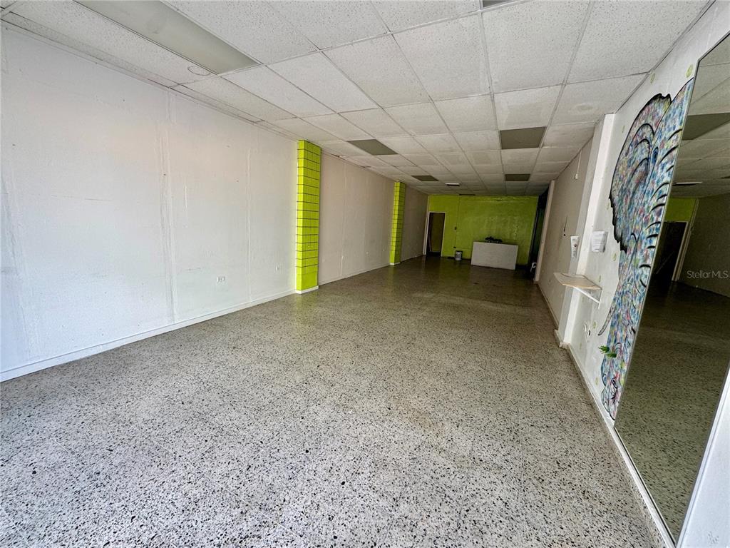 An empty commercial space features white walls, lime green accents, and a speckled tile floor — 8 DR. VIDAL, HUMACAO, PR