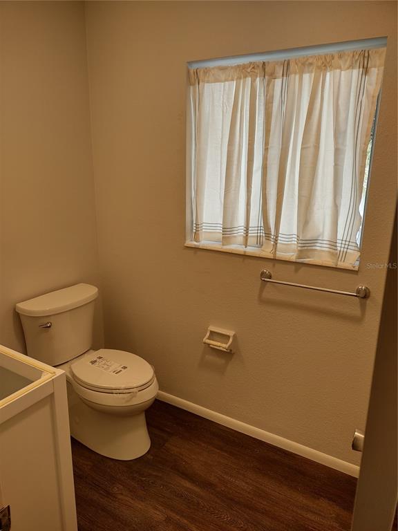 A dining area with a glass table and two blue chairs sits on carpeted flooring — 1538 PLEASANT ROAD UNIT G34, BRADENTON, FL